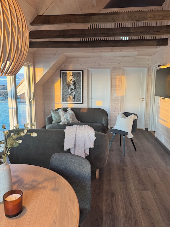 Une piĂšce comprenant un lit, une chaise, une table, un tableau et une porte.