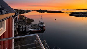 Une propriété située au bord de l’eau, dotée d’un quai, d’un bateau et d’un bâtiment à la façade rouge.