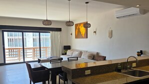 Una cocina moderna con comedor, dispensador de agua y un amplio ventanal con vistas.