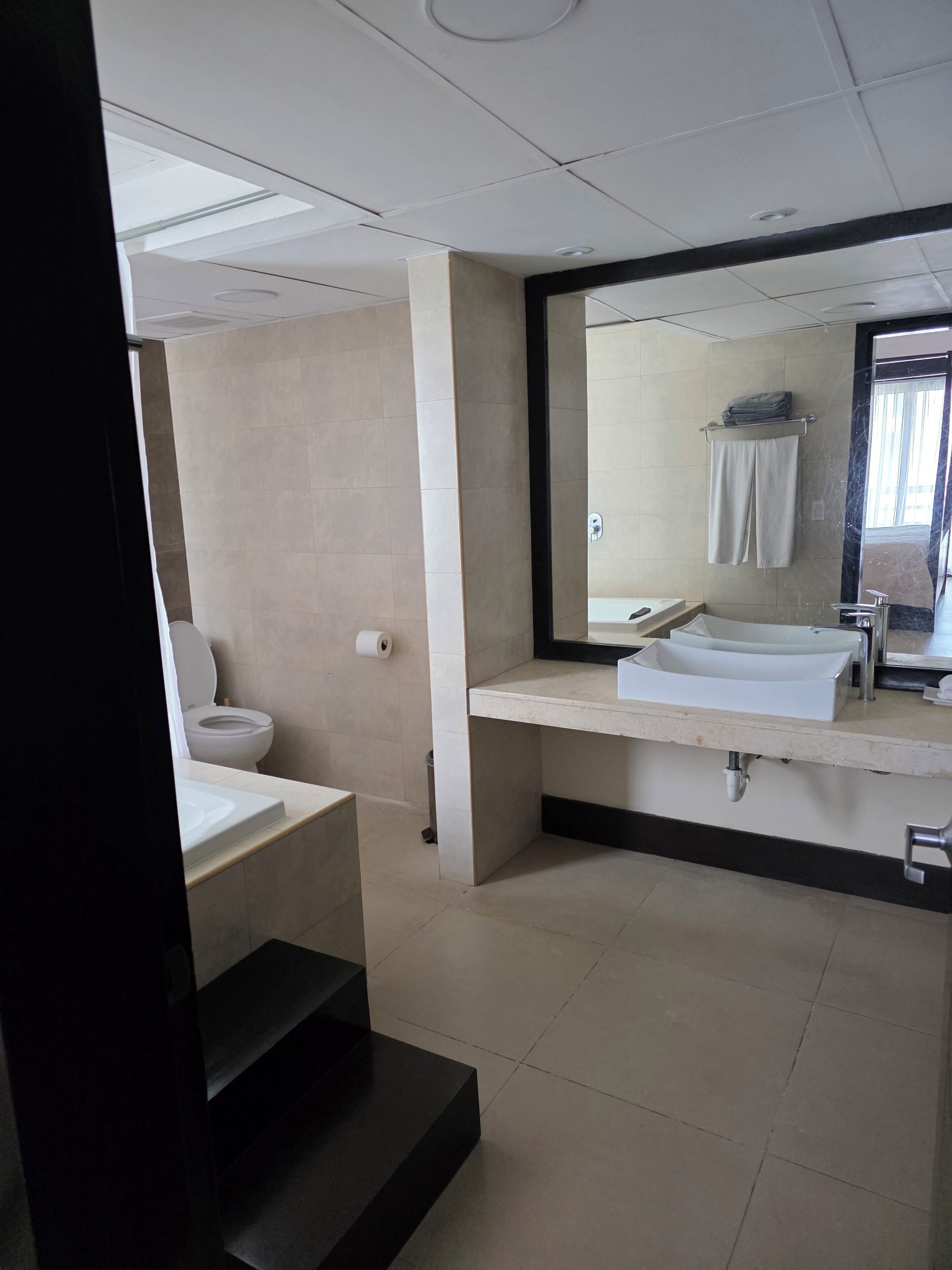 A modern bathroom with a toilet, sink, and mirror.