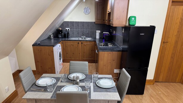 Una cocina compacta con comedor, lavadora y refrigerador.
