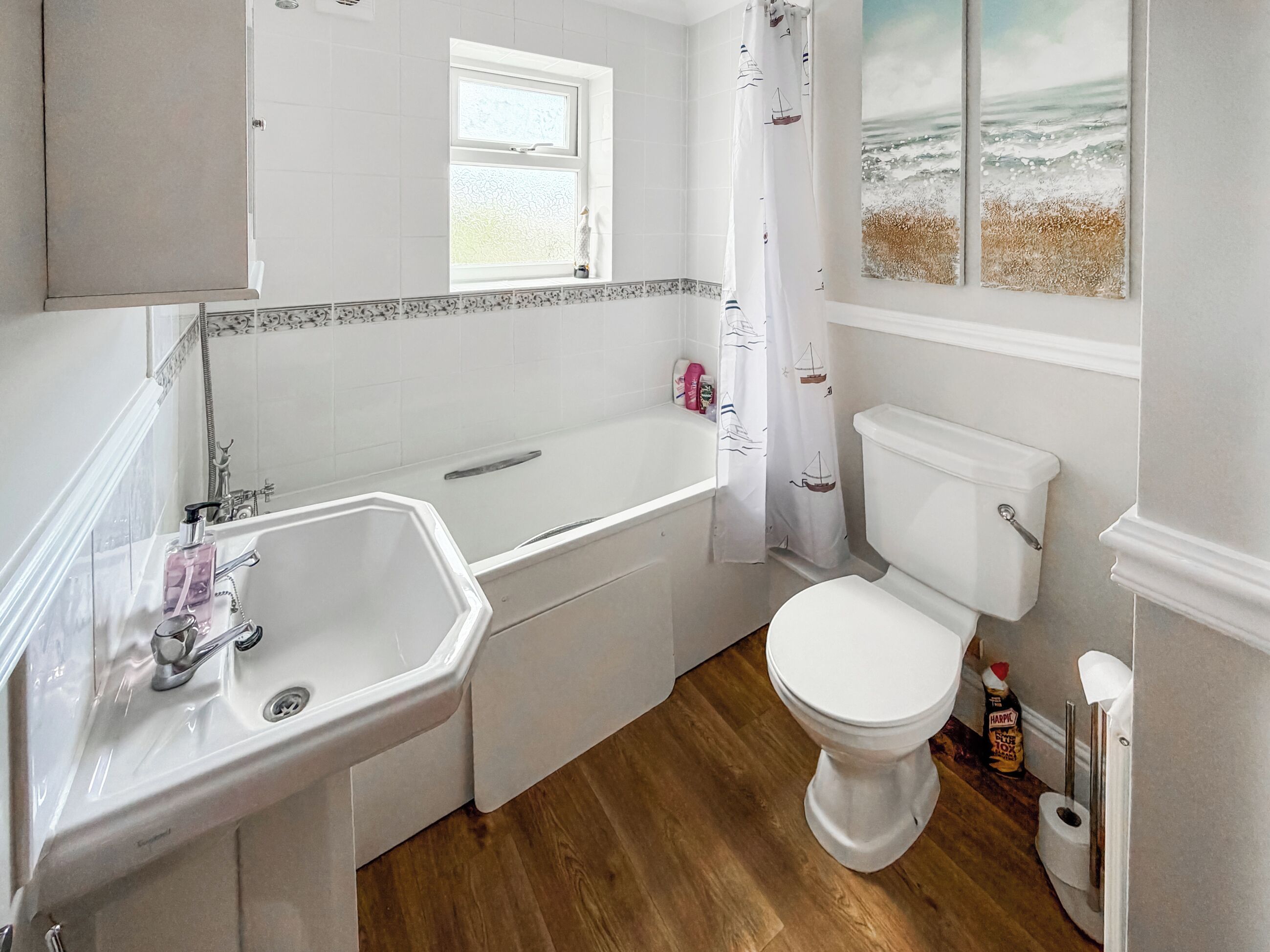 A bathroom with a bathtub, toilet, and sink.