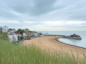 Eine Küstenstadt mit Sandstrand, einer Seebrücke und Gebäuden entlang der Uferlinie.