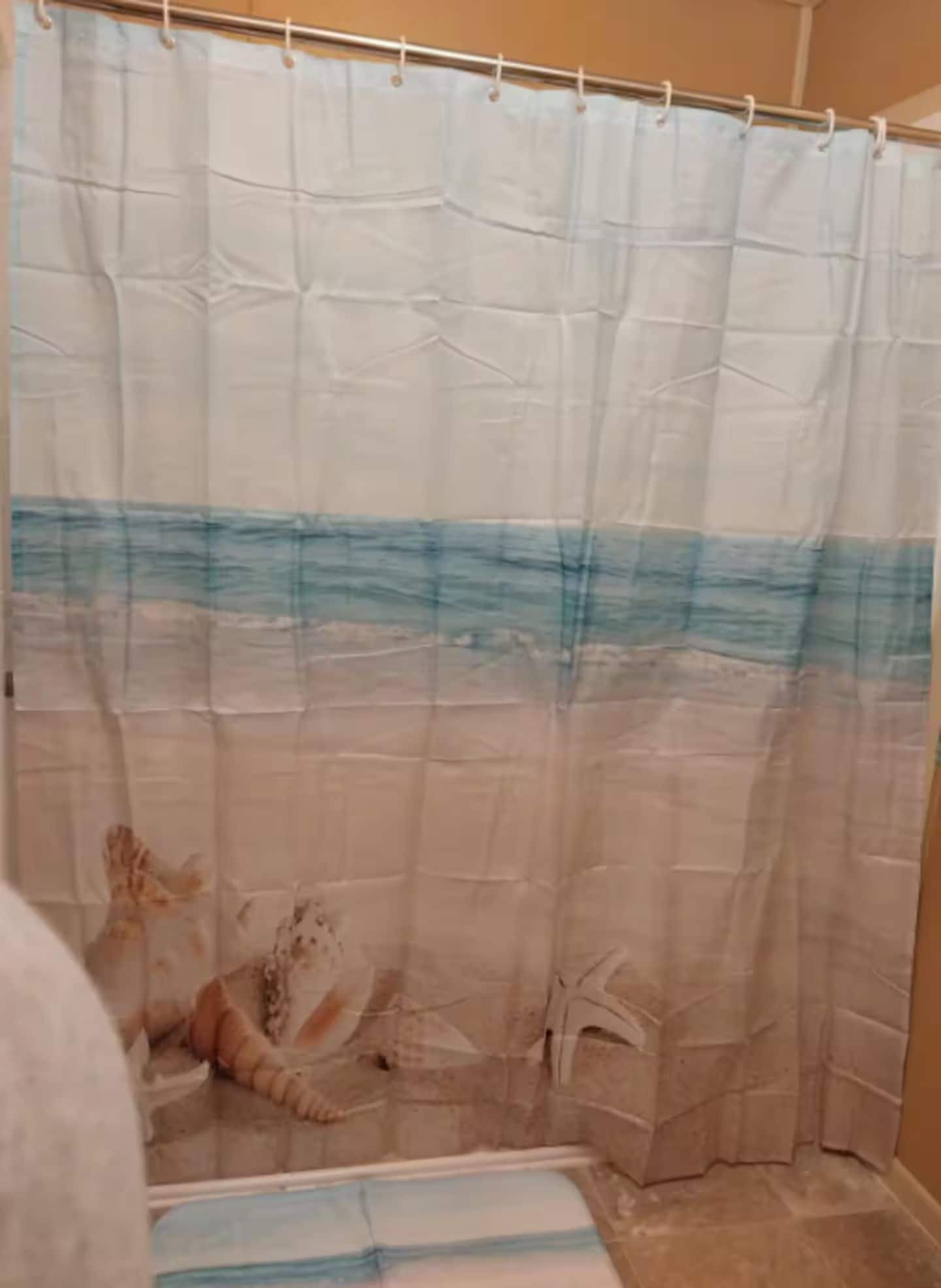 A shower curtain with a beach scene design.