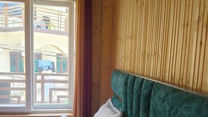 A room with a bed, a window, and wooden walls. - Yamuna pag pinewood hotel  (Rajgarhi)