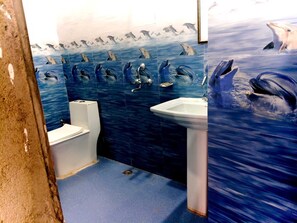 Une salle de bain avec des carreaux bleus, des toilettes et un lavabo.