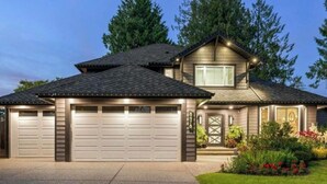 A two-story house with a garage, a front door, and a small porch.