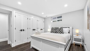 A bedroom with a bed, bedside table, and a wardrobe.