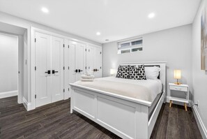 A bedroom with a bed, bedside table, and a wardrobe. - Charming 2BR Getaway| Near Fort Langley| Fast WiFi (Langley Township)