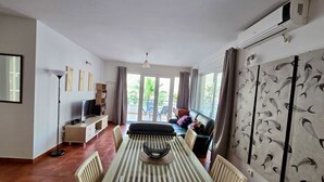 A spacious living area with a large dining table, a sofa, a TV, and a view through the glass doors. - The Breathtaking Views - Kotorscapes II (Muo)