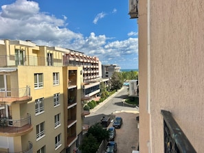 Un immeuble résidentiel à plusieurs étages, doté de balcons, d’un espace de stationnement et offrant une vue dégagée sur la mer.