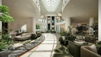 A spacious lobby with a central walkway, seating areas, and a high ceiling with skylights.