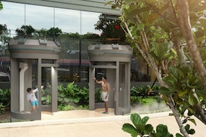 Un bâtiment moderne doté d’une façade en verre, d’un élément décoratif aquatique et d’un espace de détente agrémenté de jardinières.