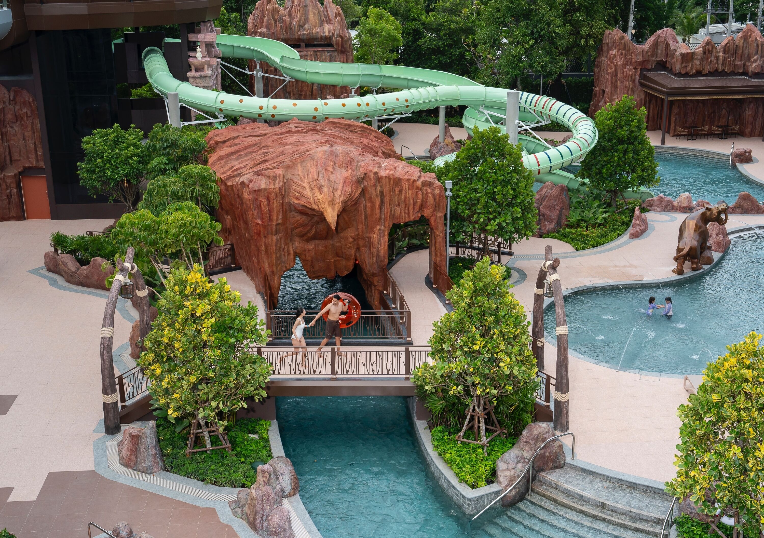 A water park with a large rock formation, slides, and pools.