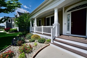Ein Wohnhaus mit Veranda, Eingangstür und gepflegtem Garten.
