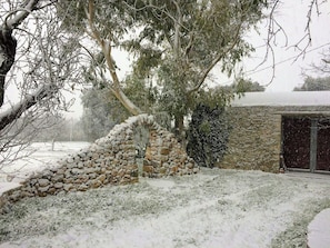 A stone wall, a tree, and a building in a snowy landscape. - Authentic trulli centrally in Valle d'Itria (Ceglie Messapica)