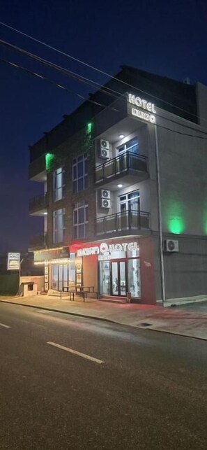 A hotel with a sign reading 'HOTEL' and 'HOTEL ORINOCO' on the facade, a balcony on the second floor, and a storefront with a sign that appears to say 'HOTEL.' - Hotel Mimino & Restaurant (Batumi)