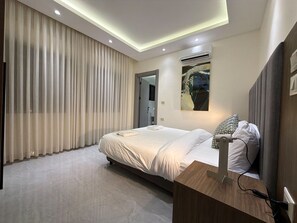 Ein modernes Hotelzimmer mit Bett, Nachttisch und Klimaanlage.