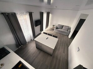 A modern living space with a kitchen, dining area, and a sofa.