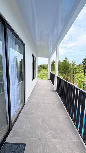 A covered balcony with a view of greenery. - View 4 Villas Vista Verde (Coronado)