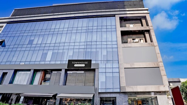 Un edificio moderno con un letrero que dice 'TOWNHOUSE' y el logotipo de la empresa.