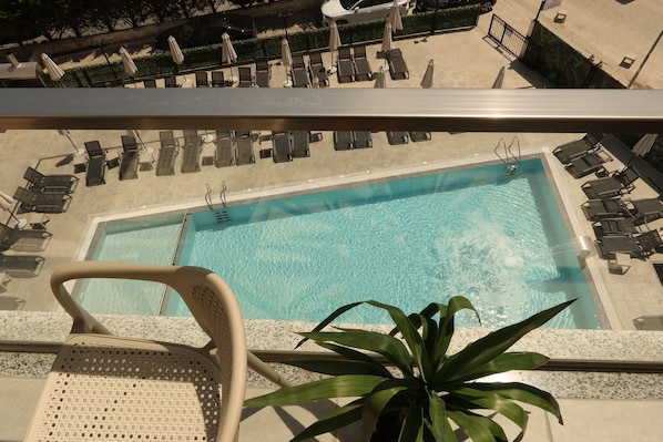 A pool area with lounge chairs and a potted plant. - PineaMare Apartaments Golem, Durres (Golem)