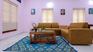 Un salon avec un canapé, une table basse et des tapis à motifs.