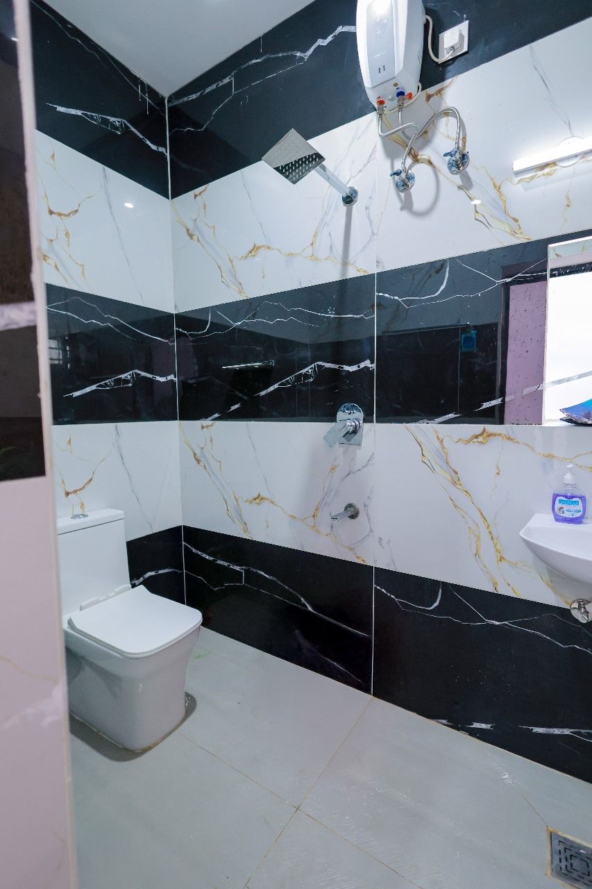 Une salle de bain comprenant des toilettes, un lavabo et un espace douche.