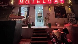 A hotel with a neon sign reading 'Mark Inn Hotel Bar' and a staircase leading to the entrance. - HOTEL MARK INN (Hanumangarh)