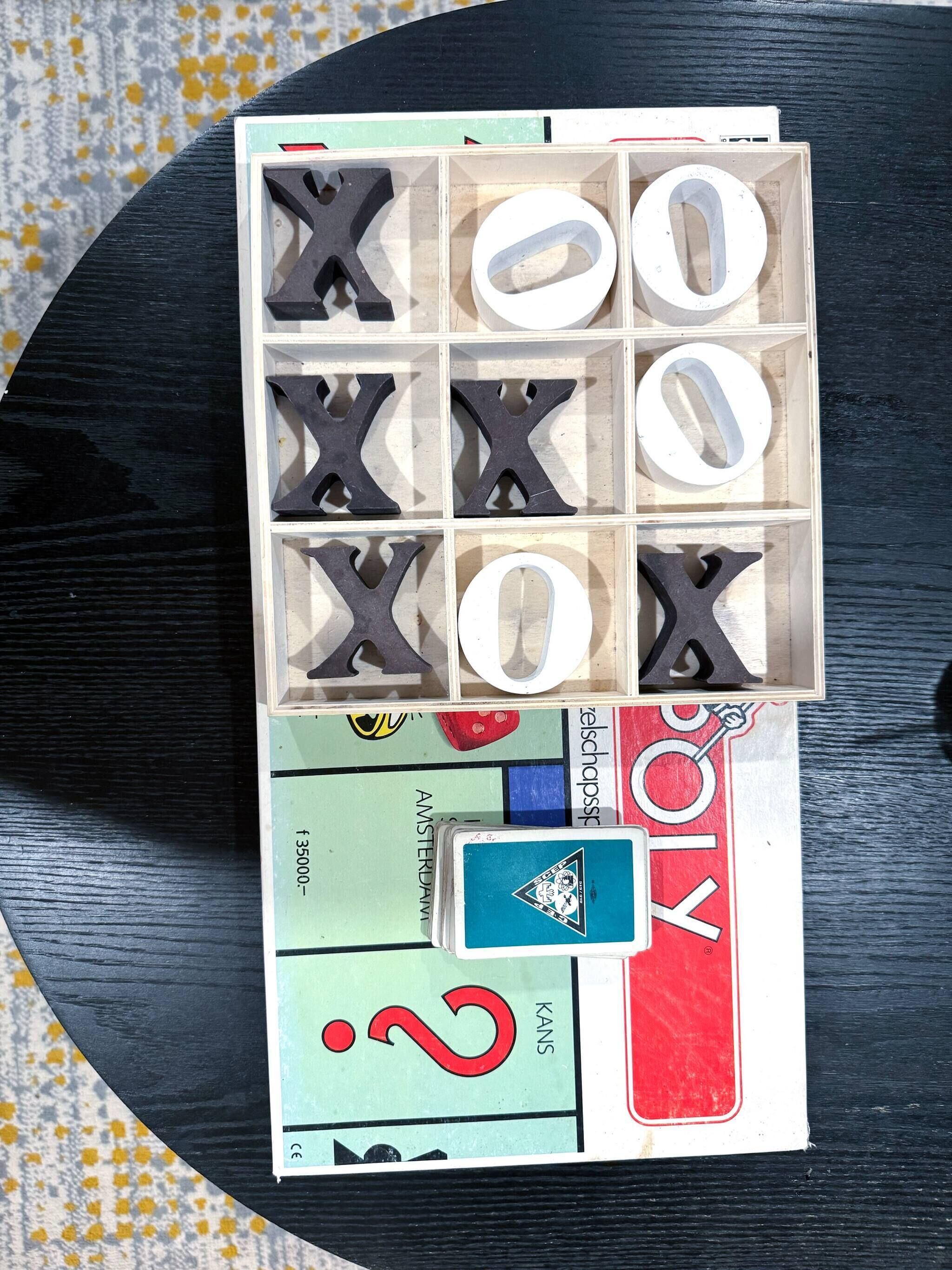 A wooden box with cut-out letters and numbers, and some stickers on a table.