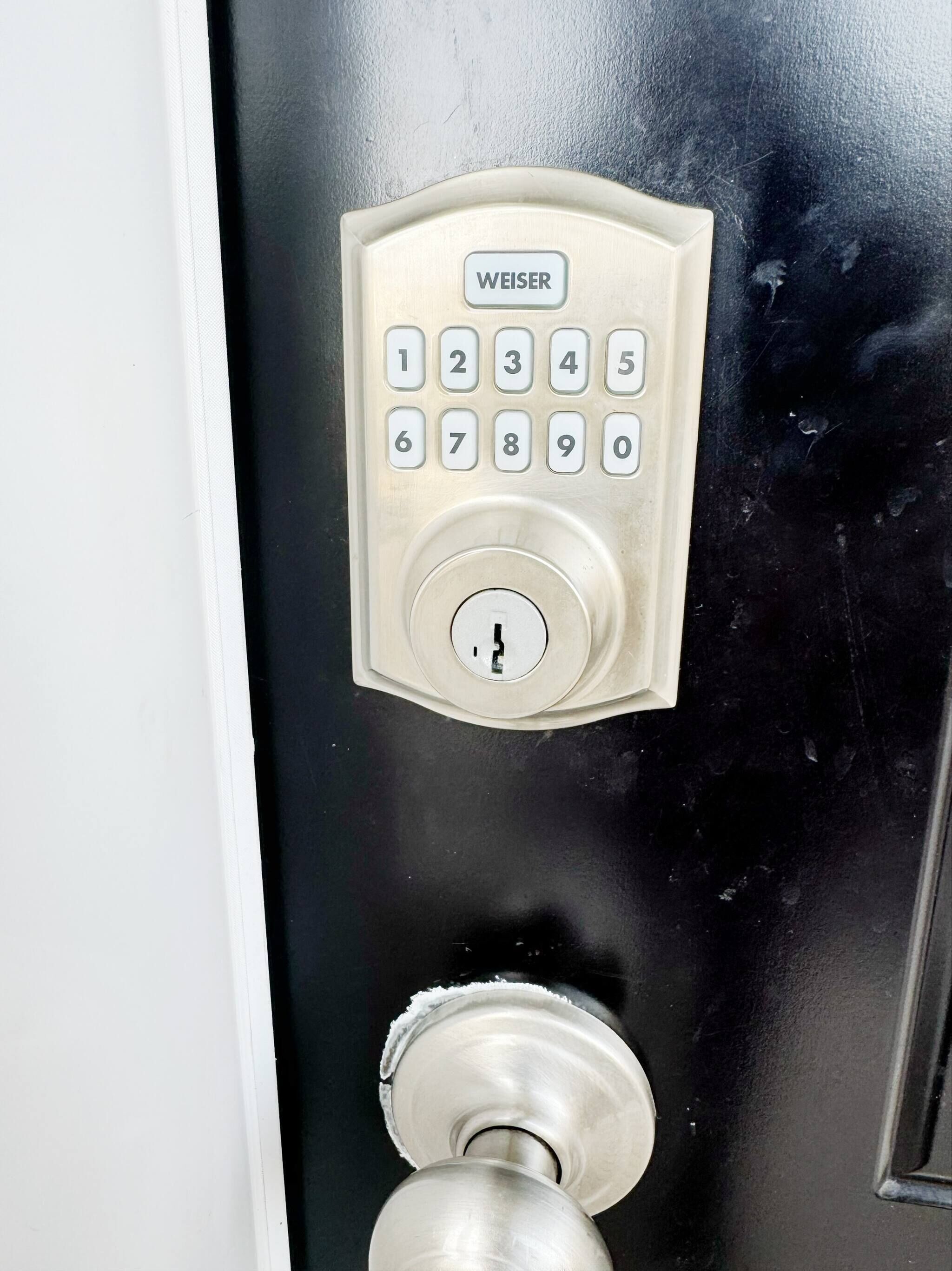 A door with a numeric keypad and a keyhole, labeled 'WEISER.'