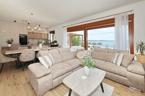 Ein modernes Wohnzimmer mit Sofa, Couchtisch und Essbereich.