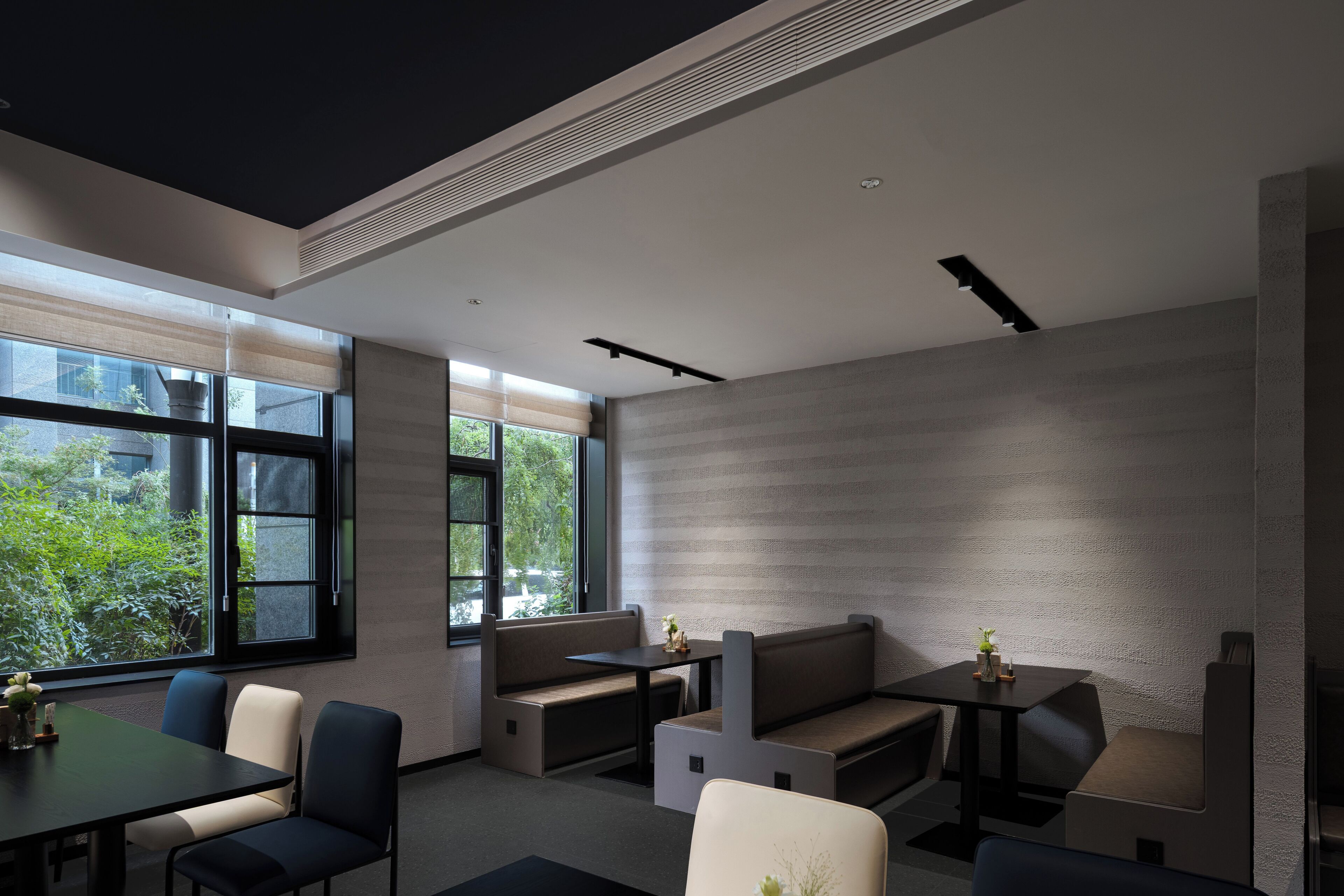 Un intérieur moderne avec une grande fenêtre, un coin salon et une table.
