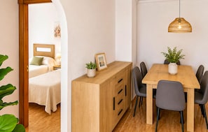 Ein Hotelzimmer mit Bett, Nachttisch und Blick durch einen Bogen.