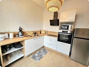 A modern kitchen with white cabinets, a stainless steel refrigerator, a microwave, and a coffee maker. - Oparadi "Le Coeur de Boulogne" (The Heart of Boulogne) (Boulogne-sur-Mer)