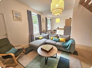 A living room with a sofa, a chair, a coffee table, and a hanging light fixture. - Oparadi "Le Coeur de Boulogne" (The Heart of Boulogne) (Boulogne-sur-Mer)