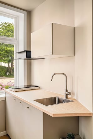 A kitchen with a window, a sink, and a built-in cabinet.