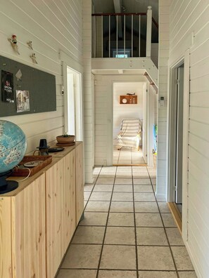 A narrow hallway with a wooden counter, a globe, and a bulletin board with various items pinned to it. - Summer house with path to pier by fjord (Skibby)