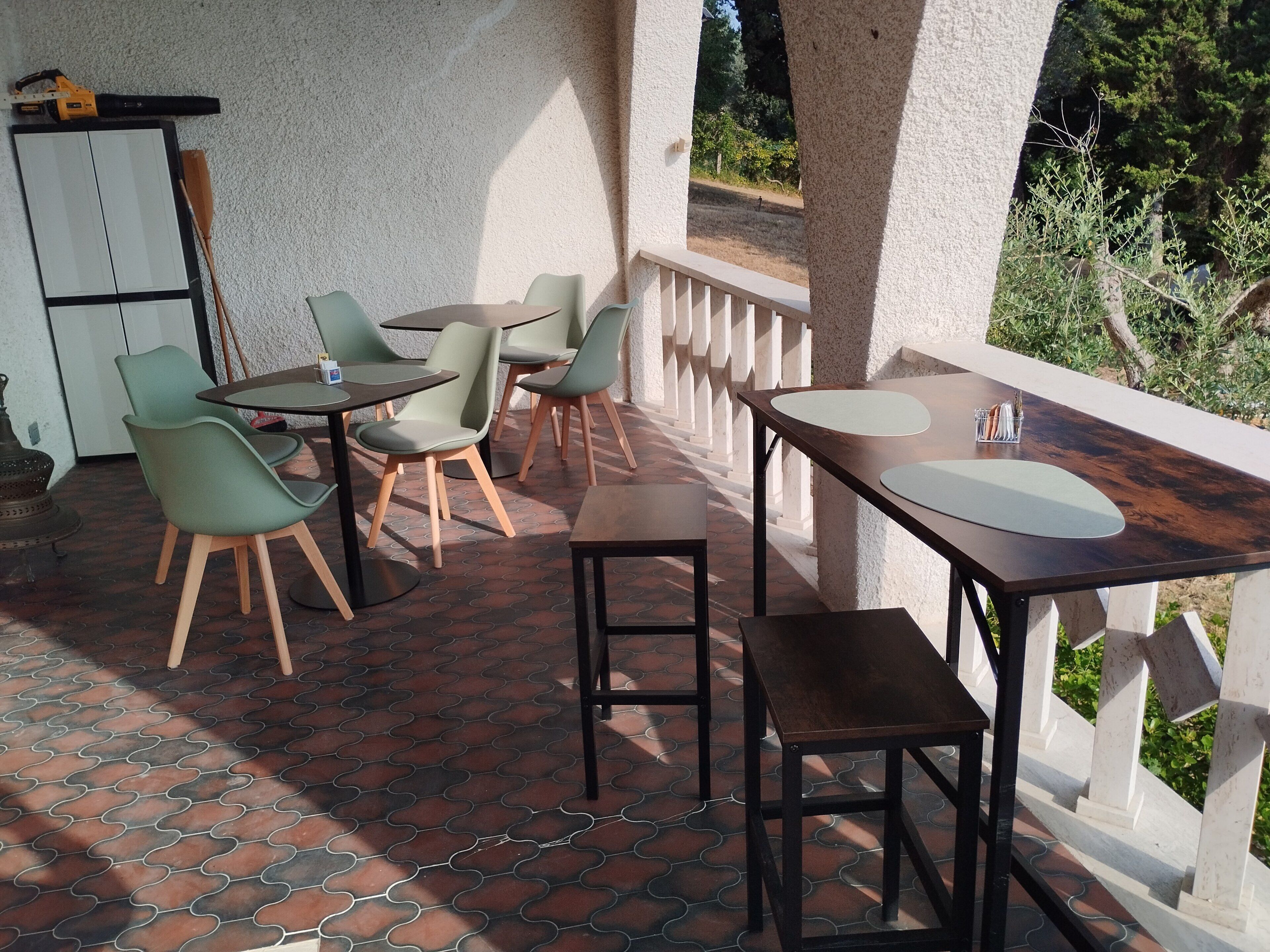 Una terrazza con posti a sedere all'aperto, un tavolo e vista sul verde.