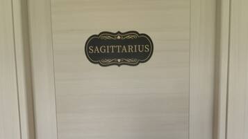 A door with a sign that reads 'SAGITTARIUS' and a keyhole with a keychain.