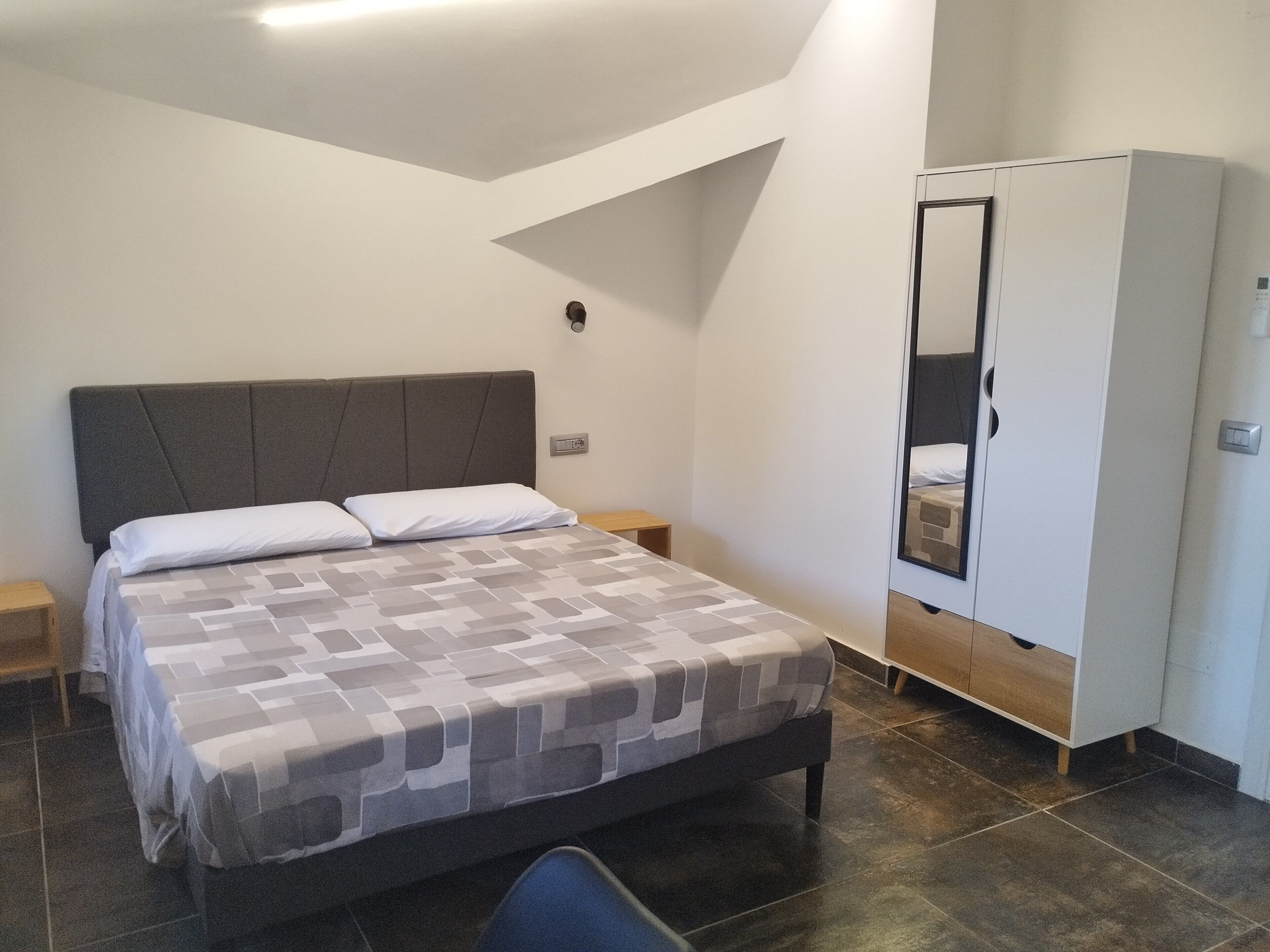 Une chambre à coucher avec un lit, une armoire et une table de chevet.