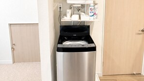 A compact, modern bathroom with a built-in water heater, a towel rack, and a small shelf with toiletries. - 3 minutes from Roppongi-itchome station! A house, 2 stories, private! Conveniently located near convenience stores [8 minutes from Roppongi Station on the Hibiya Line]. (Minatoku)