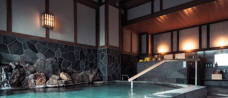 A stone wall, wooden beams, a pool, and a staircase.
