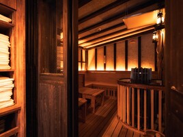 Un interior de madera con una zona de estar, una barra y una ventana con persianas.