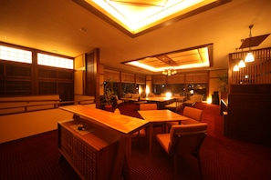 Ein traditionelles japanisches Restaurant mit Holzmöbeln, einem roten Teppich und warmer Beleuchtung.