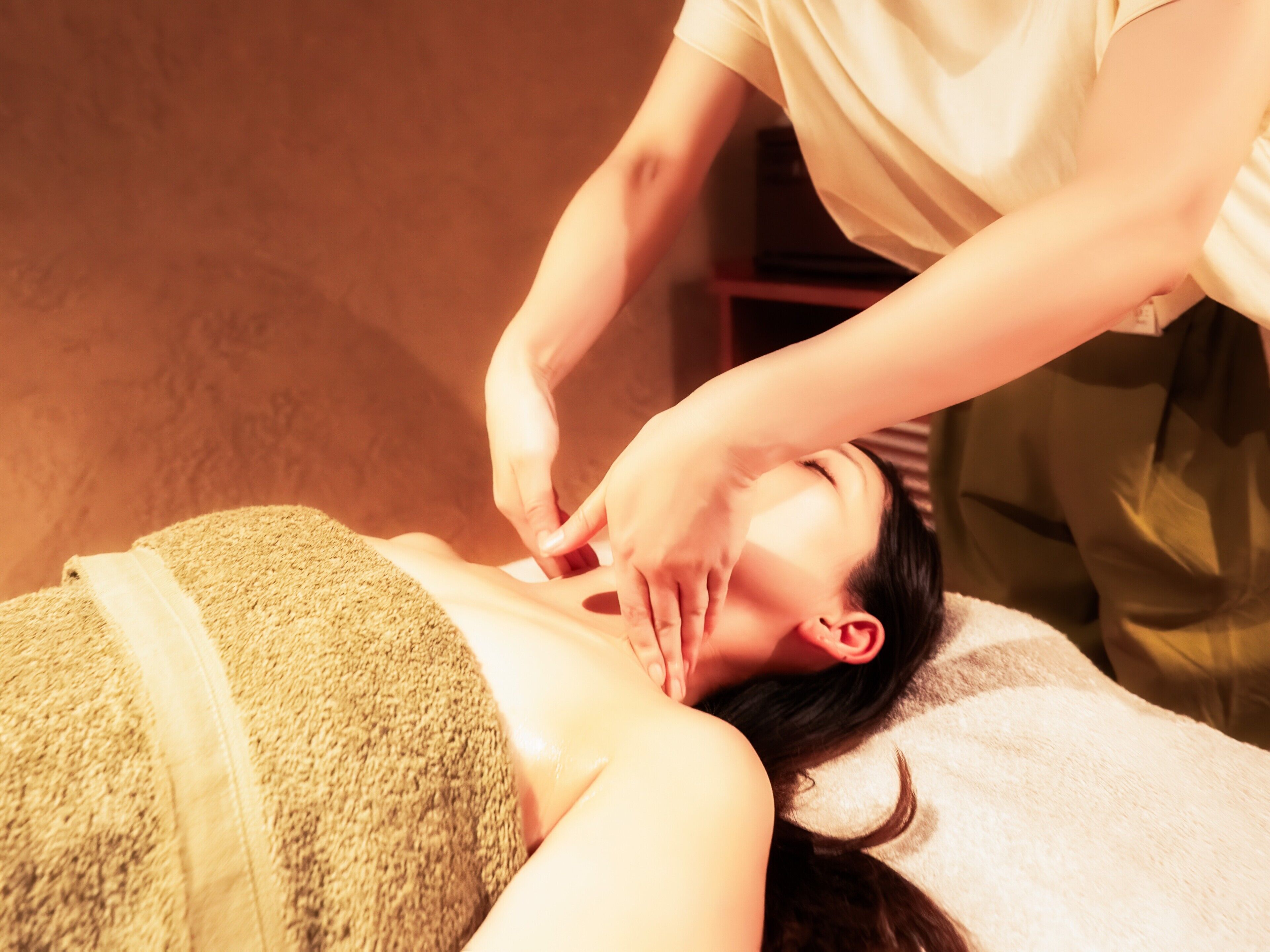 A person receiving a massage with a towel wrapped around their body.