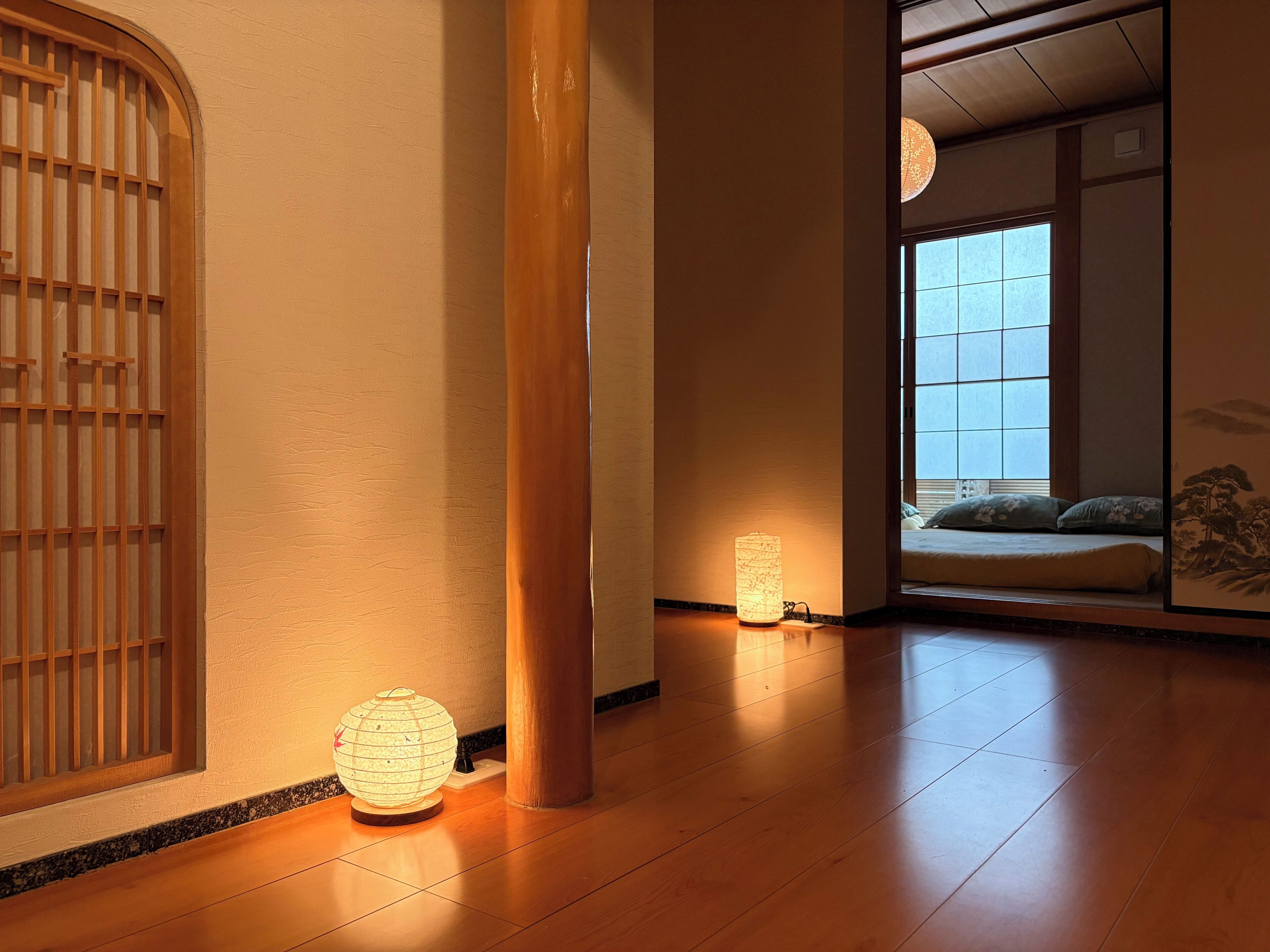 A traditional interior with tatami flooring, a shoji screen, and a hanging lantern.