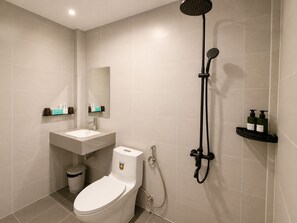 Et moderne badeværelse med toilet, vask og brusebad.