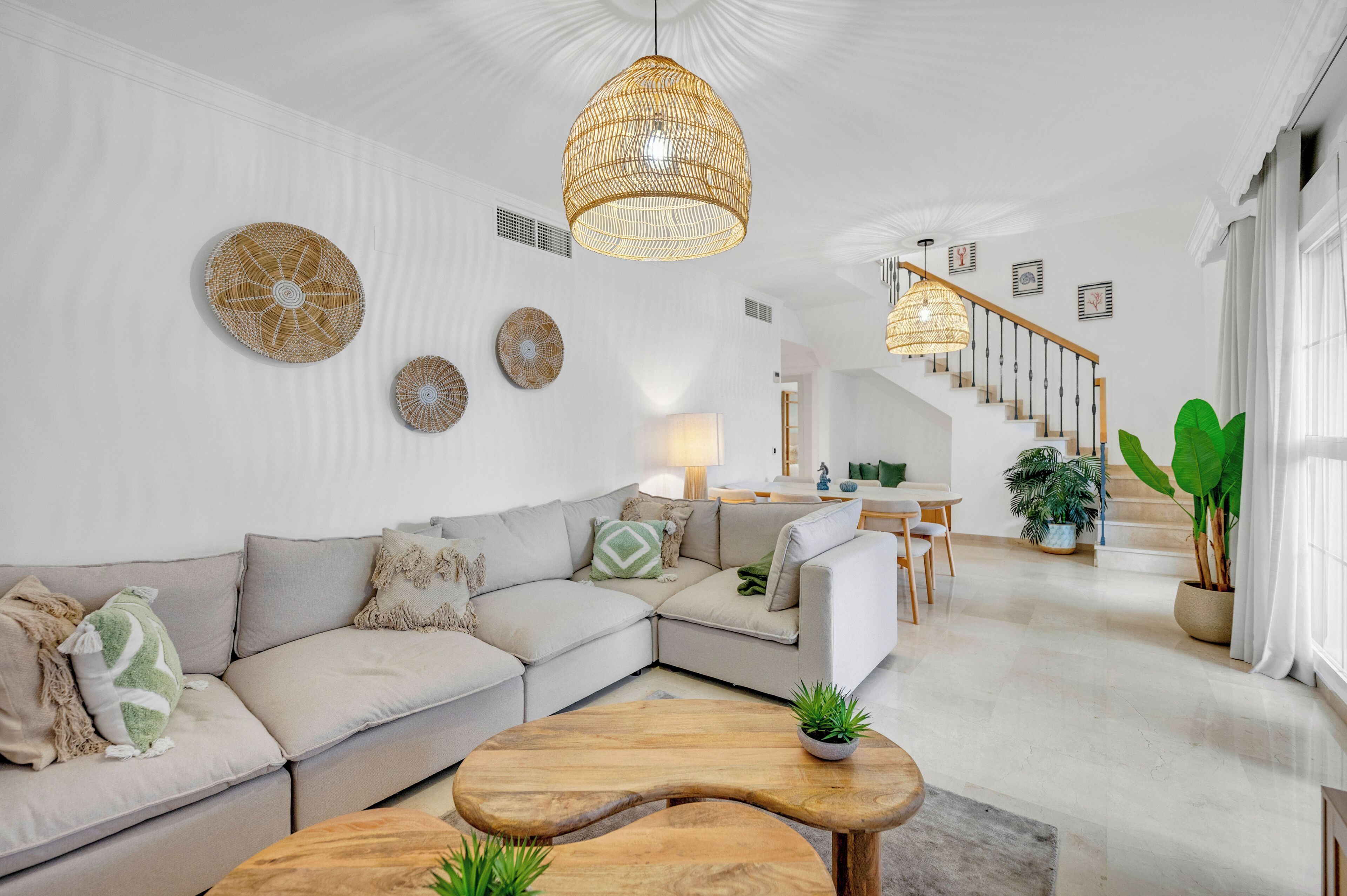 A modern living room with a sofa, coffee table, and hanging light fixture.