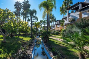 Ein Resort mit Wasserspiel, Palmen und einem Weg.